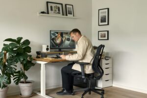 höhenverstellbarer Schreibtisch im Homeoffice – ergonomischer Arbeitsplatz mit Monitor und Bürostuhl