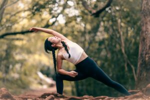Bewegung im Homeoffice – Frau macht Yoga-Übung im Freien zur Entspannung und Konzentrationssteigerung